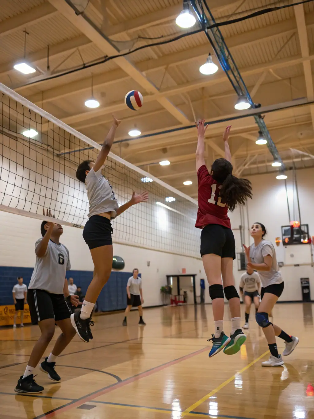Students engaged in a volleyball match, demonstrating agility and communication skills.